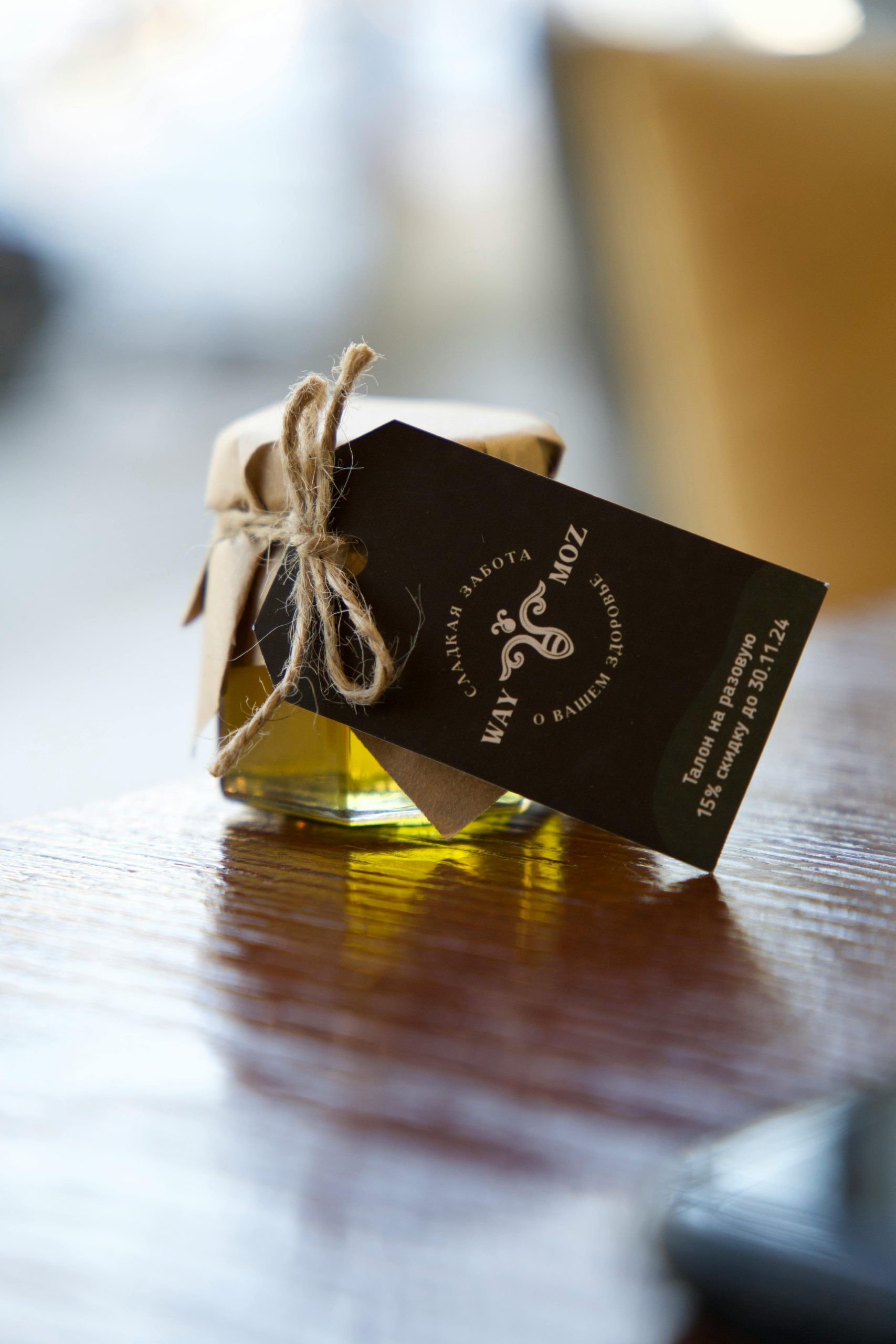 Close-up of a glass jar filled with natural olive oil, elegantly packaged.